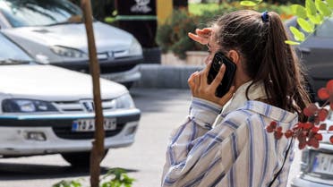A woman speaks on a cell phone along a street in Tehran, Iran, on September 4, 2023. (AFP)