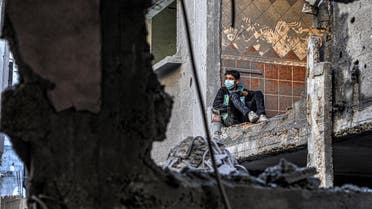 A boy looks on while sitting by a damaged wall in a building next to another destroyed by Israeli bombardment in Rafah in the southern Gaza Strip on December 24, 2023 amid the ongoing conflict between Israel and the militant group Hamas. (Photo by SAID KHATIB / AFP)