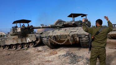 An Israeli soldier directs a tank near the border with the Gaza Strip in southern Israel on December 25, 2023, amid ongoing battles between Israel and the militant group Hamas. (Photo by Menahem Kahana / AFP)