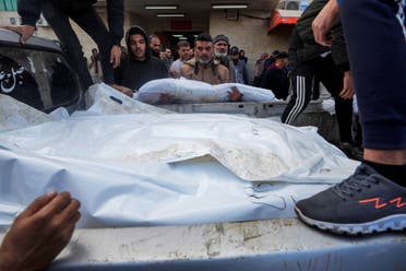 Palestinians load the bodies of their relatives killed in the Israeli bombardment of the Gaza Strip on a truck, to be buried at the cemetery in Deir al Balah, Gaza Strip, December 25, 2023. (AP)