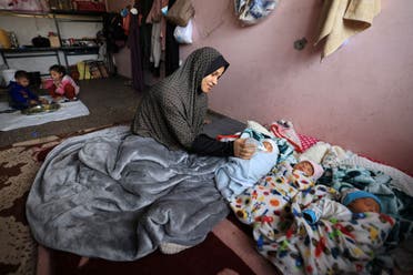 Iman al-Masri, a displaced Palestinian who fled from her home in Beit Hanoun with her family to escape Israeli bombardment, feeds one of her quadruplets - with the fourth still being treated in hospital - as they take shelter at a school in Deir al-Balah in the central Gaza Strip on December 27, 2023, amid continuing battles between Israel and the militant Hamas group. (AFP)