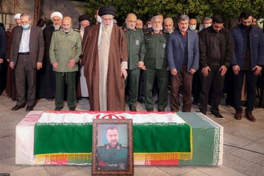 A handout picture provided by the office of Iran’s Supreme Leader Ali Khamenei on December 28, 2023, shows him praying next to the coffin of Seyed Razi Mousavi, a senior commander in the Quds Force of Iran’s Islamic Revolutionary Guard Corps (IRGC) who was killed on December 25 in an Israeli strike in Syria, in Tehran. (AFP)
