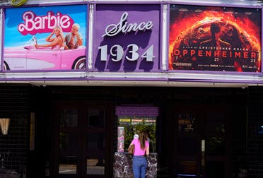 A patron buys a movie ticket underneath a marquee featuring the films Barbie and Oppenheimer at the Los Feliz Theatre, Friday, July 28, 2023, in Los Angeles. (AP)