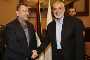 In this photo released by the Hamas Media Office, Ismail Haniyeh, right, the head of the Hamas political bureau, shakes hands with his deputy Saleh al-Arouri upon his arrival in Gaza from Cairo, Egypt, in Gaza City, August 2, 2018. (AP)