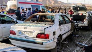 People stay next to destroyed cars after an explosion in Kerman, Iran, January 3, 2024. (Tasnim News Agency via AP)