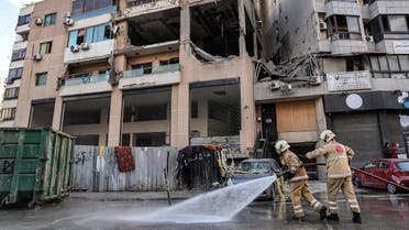 TOPSHOT - Lebanese civil defence members spray with water the street by the building that was hit by an Israeli strike targeting Hamas deputy leader Saleh al-Aruri in the southern suburb of Beirut on January 3, 2024. Aruri was killed on January 2 along with his bodyguards in a strike by Israel, which has vowed to destroy Hamas after the movement's shock October 7 attacks. Israel has previously announced the deaths in Gaza of Hamas commanders and officials during the war, but Aruri is the most high-profile figure to be killed, and his death came in the first strike on the Lebanese capital since hostilities began. (Photo by ANWAR AMRO / AFP)