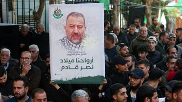 A person holds a placard displaying the photo of late Hamas deputy leader Saleh al-Arouri during the funeral of Ahmad Hammoud, who was killed along with al-Arouri of what security sources said was an Israeli drone strike in Beirut on Tuesday, in Burj al-Shemali in Tyre, Lebanon, January 3, 2024. REUTERS/Aziz Taher
