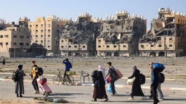 Residents of Hamad Town residential complex in Khan Younis in the southern Gaza Strip, carry some of their belongings as they flee their homes after an Israeli strike, on December 2, 2023. (AFP)