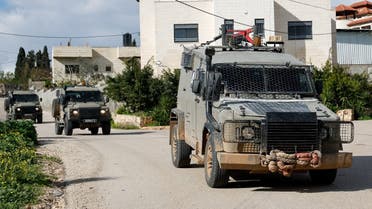 Military vehicles drive amid an Israeli operation in Sir, near Jenin in the Israeli-occupied West Bank, on January 4, 2024. (Reuters)