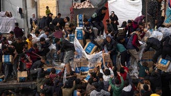 Dozens of hungry Palestinians surround aid trucks bound for northern Gaza