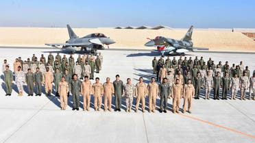 In this handout photograph, taken and released by the Directorate General Public Relations Pakistan Air Force, contingents from Pakistan Air Force and Qatar Emiri Air Force pose for a group photo during the opening ceremony of joint aerial exercise Zilzal II in Qatar on January 10, 2024. (Photo courtesy: PAF)