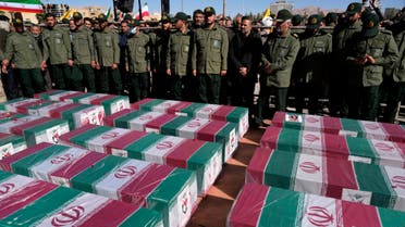 People pray over the flag-draped coffins of victims of Wednesday's bomb explosion during their funeral ceremony in the city of Kerman about 510 miles (820 kms) southeast of the capital Tehran, Iran, Friday, Jan. 5, 2024. Iran on Friday mourned those slain in an Islamic State group-claimed suicide bombing targeting a commemoration for a general slain in a U.S. drone strike in 2020. (AP Photo/Vahid Salemi)