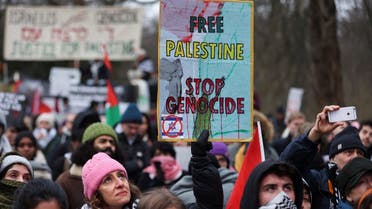 A pro-Palestinian demonstrator holds a placard during a protest near the International Court of Justice (ICJ) on the day judges hear a request for emergency measures to order Israel to stop its military actions in Gaza, in The Hague, Netherlands, on January 11, 2024. (Reuters)
