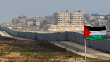 A Palestinian flag is seen with the background of a section of the wall in the Philadelphi corridor between Egypt and Gaza, on the background, near the southern Gaza Strip town of Rafah Sunday, July, 1, 2007. Around 200 Hamas men were deployed Sunday along the border, part of the organization's push to fill the vacuum left by the disappearance of security forces from Fatah, defeated by Hamas in mid-June. (AP Photo/Khalil Hamra)