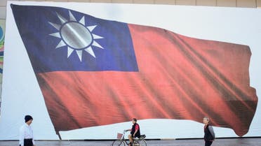 People walk past a Taiwanese flag in New Taipei City on January 13, 2024. (AFP)