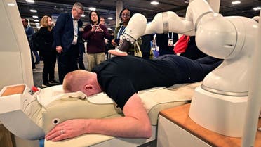 A man experiences an iYU Spa massage from Capsix Robotics, an AI assisted massage therapy device during a display at the Consumer Electronics Show (CES) in Las Vegas, Nevada on January 10, 2024. (AFP)