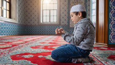 Cute little muslim boy praying in Mosque stock photo