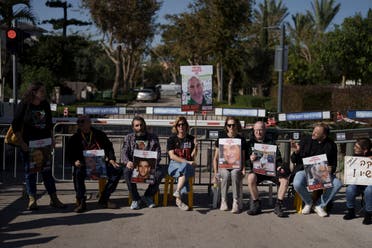 Relatives and friends of hostages sit on a street outside the private residence of the Israeli Prime Minister Benjamin Netanyahu, in Caesarea, Israel, Saturday, Jan. 20, 2024, in support of a father of an Israel hostage held in Gaza who has begun a hunger strike to protest the government's lack of visible progress on a new hostage deal. (AP Photo/Leo Correa)