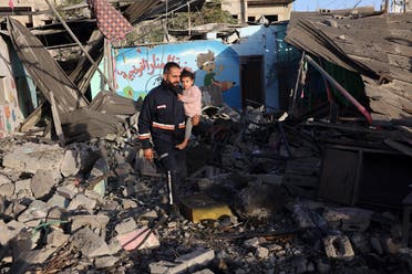 A rescuer carries a child as he walks amid the rubble of a school hit during an Israeli strike before the start of a four-day truce in the battles between Israel and Hamas militants, in Rafah in the southern Gaza Strip on November 24, 2023. (File photo: AFP)