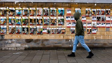 A person walks past a wall with pictures of hostages who were taken by Hamas gunmen on October 7, amid the ongoing conflict between Israel and the Palestinian Islamist group Hamas, in Tel Aviv, Israel, January 26, 2024. (Reuters)