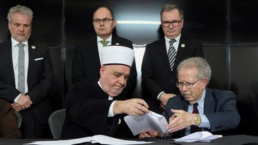 The President of the World Federation of Bergen-Belsen Associations and American lawyer, Menachem Rosensaft (R) and the religious leader of Bosnian Muslims, Husein Kavazovic (L) sign a Jewish-Muslim Initiative for Peace at the Srebrenica Genocide Memorial Centre in Srebrenica, on January 27, 2024, on International Holocaust Remembrance Day, as deadly fighting rages in the Gaza Strip. (AFP)
