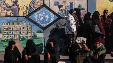 Displaced Palestinians queue to receive aid in front of the United Nations Relief and Works Agency for Palestine Refugees (UNRWA) center in Rafah in the southern Gaza Strip on January 28, 2024, amid ongoing battles between Israel and the Palestinian militant group Hamas. (AFP)