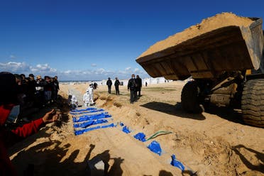 People bury Palestinians, including those who were killed in Israeli strikes and fire, after their bodies were released by Israel, according to Palestinian health ministry officials, amid the ongoing conflict between Israel and Hamas, at a mass grave in Rafah, in the southern Gaza Strip, on January 30, 2024. (Reuters)