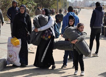 Palestinians, fleeing Khan Younis, walk with their belongings toward Rafah, during the Israeli ground operation against Palestinian group Hamas, in the southern Gaza Strip, on January 30, 2024. (Reuters)