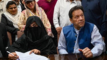 Pakistan's former Prime Minister, Imran Khan (R) along with his wife Bushra Bibi (L) looks on as he signs surety bonds for bail in various cases, at a registrar office in the High court, in Lahore on July 17, 2023. (File photo: AFP)
