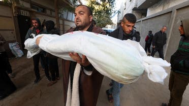 A mourner carries the body of a Palestinian child killed in Israeli strikes, amid the ongoing conflict between Israel and the Palestinian Islamist group Hamas, in Rafah, in the southern Gaza Strip, February 4, 2024. REUTERS/Ibraheem Abu Mustafa