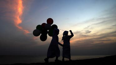 Children carrying balloons, play on the shore of the Gulf island of Dalma, off the coast of the Emirati capital Abu Dhabi, on November 4, 2022. (File photo: AFP)