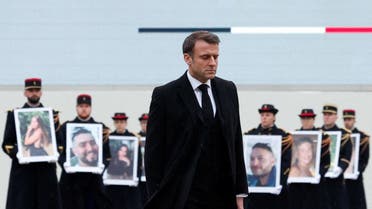 French President Emmanuel Macron walks past French Republican Guards who hold portraits of the 42 French citizens killed of the Hamas attacks during a tribute ceremony to the victims of the Hamas assault on Israel last October 7. (AFP)