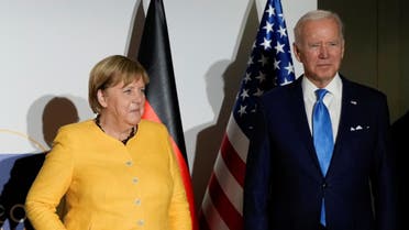 Germany s Chancellor Angela Merkel and U.S. President Joe Biden pose the media prior to a meeting during the G20 leaders' summit in Rome, Italy October 30 2021 Kirsty WigglesworthPool via REUTERS