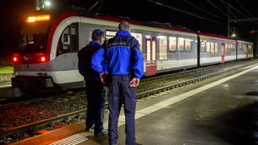 Vaud cantonal police officers watch the Travys train where a hostage-taking incident took place at Essert-sous-Champvent station, Switzerland, Thursday, Feb. 8, 2024. A hostage-taking incident took place on a regional train between Yverdon and Sainte-Croix at around 6: 30 p.m. on Thursday. All hostages were freed and are safe. (Laurent Gillieron/Keystone via AP)