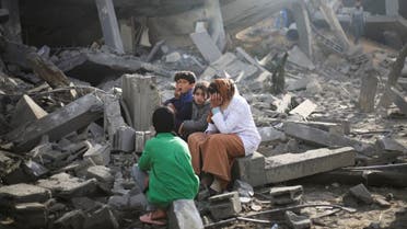 Palestinians sit by the destruction from the Israeli bombardment of the Gaza Strip in Rafah, Feb. 12, 2024. (AP)