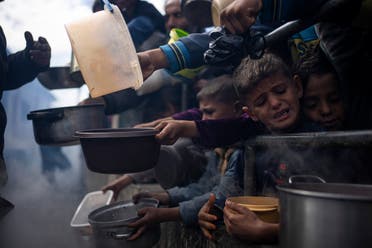 Palestinians line up for a free meal in Rafah, Gaza Strip, Friday, Feb. 16, 2024. International aid agencies say Gaza is suffering from shortages of food, medicine and other basic supplies as a result of the war between Israel and Hamas. (AP Photo/Fatima Shbair)