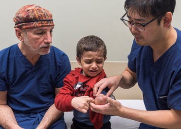 Plastic surgeon Dr. Eugene Park and orthopedic surgeon Dr. Scott Kozin examine the arm of 4-year-old Omar Abu Kuwaik at Shriners Children's Hospital on Wednesday, Feb. 28, 2024, in Philadelphia. (AP)