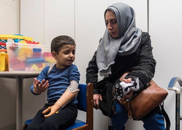 Four-year-old Omar Abu Kuwaik expresses frustration at using his new prosthetic arm with his aunt, Maha Abu Kuwaik, during an occupational therapy session at Shriners Children's Hospital on Wednesday, Feb. 28, 2024, in Philadelphia. (AP)