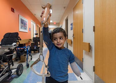 Four-year-old Omar Abu Kuwaik holds his new prosthetic arm in the air at Shriners Children's Hospital on Wednesday, Feb. 28, 2024, in Philadelphia. (AP)