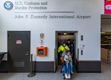 Four-year-old Omar Abu Kuwaik, and his aunt Maha Abu Kuwaik, both from Gaza, are escorted through John F. Kennedy International Airport after departing a flight from Egypt on Wednesday, Jan. 17, 2024, in New York. (AP)