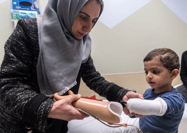 Maha Abu Kuwaik helps her nephew, 4-year-old Omar Abu Kuwaik, attach his new prosthetic arm at Shriners Children's Hospital on Wednesday, Feb. 28, 2024, in Philadelphia. (AP)