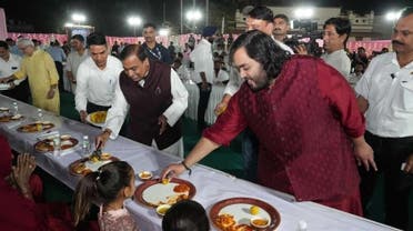 رجل الأعمال الهندي موكيش أمباني وابنه أنانت خلال إطعامهما فقراء في احتفال ما قبل زفاف أنانت في جامناجار
