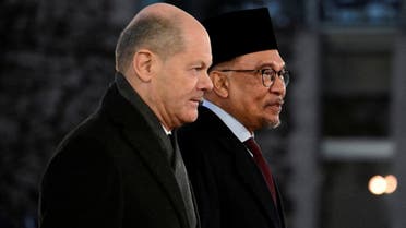 German Chancellor Olaf Scholz (L) and Malaysian Prime Minister Anwar Ibrahim walk side by side after reviewing a military honour guard during an official welcoming ceremony prior to talks at the Chancellery in Berlin on March 11, 2024. (AFP)