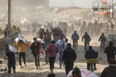 Palestinians run along a street as humanitarian aid arrives in Gaza City on March 6, 2024, amid the ongoing conflict between Israel and the Hamas militant group. (AFP)