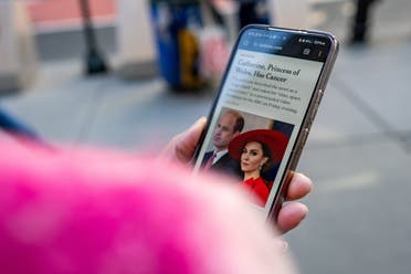 Una persona usa un teléfono celular para leer un artículo de noticias sobre el anuncio de Catalina de Gran Bretaña, Princesa de Gales, de que está recibiendo quimioterapia preventiva después de que las pruebas realizadas después de su cirugía abdominal en enero revelaran que había habido cáncer, en la ciudad de Nueva York, EE.UU. 22 de marzo de 2024. (Reuters)