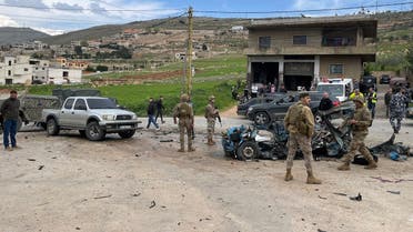 Members of the Lebanese army stand next to a car damaged by an Israeli strike near the Syrian border. (Lebanese Civil Defense on X) 