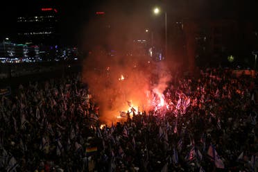 Los israelíes que se oponen al plan de reforma judicial del primer ministro Benjamin Netanyahu encendieron hogueras y bloquearon una carretera durante una protesta momentos después de que el líder israelí despidiera a su ministro de defensa, en Tel Aviv, Israel, el domingo 26 de marzo de 2023. (AP)