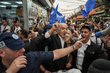 El líder del partido Likud y ex primer ministro israelí, Benjamin Netanyahu, en el centro, rodeado de seguridad y sus partidarios visitan el mercado Hatikva en Tel Aviv, Israel, el viernes 28 de octubre de 2022, durante su campaña antes de las elecciones del país.  (AP)