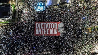 Esta vista aérea muestra a los manifestantes desplegando una pancarta gigante contra el primer ministro israelí, Benjamin Netanyahu, durante una manifestación contra el plan de reforma judicial del gobierno israelí cerca del centro comercial Azrieli en Tel Aviv el 23 de septiembre de 2023. (Foto de archivo: AFP)