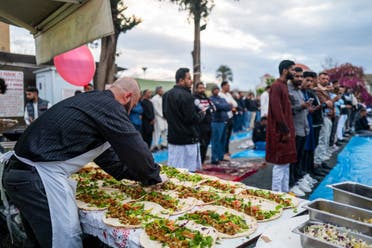 A vendor prepares food as Muslims wait to offer special morning prayers to start the Eid al-Fitr festival, which marks the end of the holy fasting month of Ramadan, outside a mosque in Nicosia on April 10, 2024. (AFP)